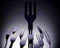 Black plastic fork surrounded by silver cutlery Royalty Free Stock Photo