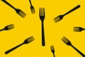 black plastic forks flying on a yellow background Royalty Free Stock Photo