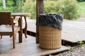 Black plastic garbage bag in a bamboo basket bin in a local natural cafe. Trash Bamboo Basket Royalty Free Stock Photo