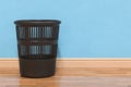 Black plastic garbage bin in room near wall. 3D rendering Royalty Free Stock Photo