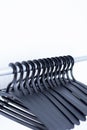 black plastic hangers hang on a light background. many different hangers Royalty Free Stock Photo