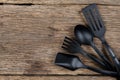 Black plastic kitchen set skimmer, spade of frying pan on wooden