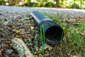 Black plastic pipe lying discarded in nature.. Royalty Free Stock Photo