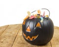 Black plastic pumpkin filled on wooden table