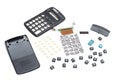 A black plastic scientific calculator dismantled showing all its internal parts
