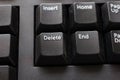 Black plastic standard English computer keyboard close up macro shot top side view delete button