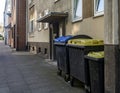 Black plastic trash containers street by day closeup Royalty Free Stock Photo