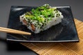 Black plate with american rolls and chopsticks Royalty Free Stock Photo