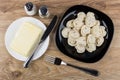 Plate with boiled dumpling, knife, butter, salt, pepper and for