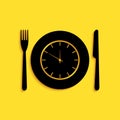 Black Plate with clock, fork and knife icon isolated on yellow background. Lunch time. Eating, nutrition regime, meal Royalty Free Stock Photo