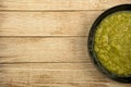 a black plate of fresh vegetable green cream soup served on rustic background Royalty Free Stock Photo