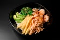 Black plate with mixed of shrimp, avocado, rice, greens and seaweed and sauce Royalty Free Stock Photo