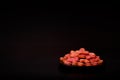 Black plate with red heart-shaped cookies on a black table, Valentine's Day.Side view, copy space Royalty Free Stock Photo