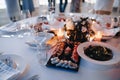 Black plate for serving sushi and rolls on a white tablecloth on the table with salad in a plate, a bouquet of white Royalty Free Stock Photo
