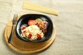 Black plate of spaghetti with baked chicken on a stand with a fork next to uncooked pasta. Royalty Free Stock Photo