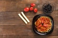 Black plate with spaghetti with sauce on a wooden table. Copy space. Royalty Free Stock Photo