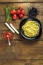 Black plate with spaghetti on a wooden table. Royalty Free Stock Photo