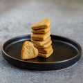 Black plate tower of heart shape cookies grey concrete background. Square. Royalty Free Stock Photo