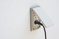 Black plug plugged in a socket with cover Royalty Free Stock Photo