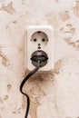 Black plug in a white double outlet on a white plaster background in a modern room interior Royalty Free Stock Photo