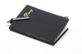 Black pocket diary and ballpoint pen