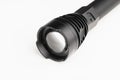 Black pocket flashlight with zoom focus lens, white background