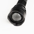 Black pocket flashlight with zoom focus lens, white background