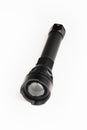 Black pocket flashlight with zoom focus lens, white background