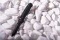 Black pocket knife on white stones. Black knife on a white background. Top Royalty Free Stock Photo