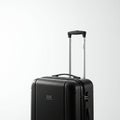 Black polycarbonate suitcase with a textured surface. Equipped with silver telescopic Royalty Free Stock Photo