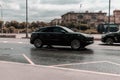 Black Porsche Cayenne car moving on the street. Compliance with speed limits on road concept