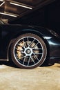 a black porsche sports car with large wheels and polished steel rims Royalty Free Stock Photo