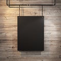 Black poster hanging on leather belt on wood background