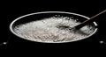 Black pot filled with boiling water and bubbles with spoon on dark background Royalty Free Stock Photo