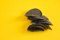 Black potato chips on yellow background. Black chips with activated charcoal and red pepper.
