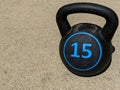 black 15 pound kettle bell sitting on concrete