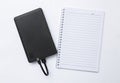 Black power bank with blank lined notebook isolate on white background