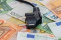 Black power plug on euro banknotes Royalty Free Stock Photo