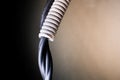 A black power wire enters a plastic gray corrugated tube close-up on a blurred background, a place for copyspace Royalty Free Stock Photo