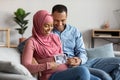 Black Pregnant Islamic Couple Holding Baby Ultrasound Scan While Sitting On Couch Royalty Free Stock Photo