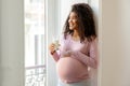 Black Pregnant Woman With Glass Of Milk Standing Near Window At Home Royalty Free Stock Photo