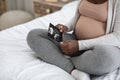 Black Pregnant Woman Looking At Ultrasound Image Of Her Baby On Bed Royalty Free Stock Photo