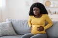 Black pregnant woman suffering from labor pains at home Royalty Free Stock Photo