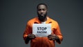 Black prisoner holding stop racism sign, psychological abuse, ill treatment