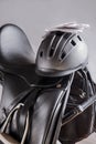 Black professional leather dressage saddle in complete with riding helmet and gloves