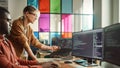 Black Programmer Shows Code On Desktop Computer to Female Start-Up Founder in Creative Office Space