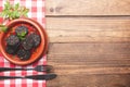 Black pudding in clay pot on rustic wooden base and checkered tablecloth. Spanish tapas Royalty Free Stock Photo