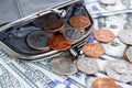 Black purse with cents on the background of hundred-dollar bills Royalty Free Stock Photo