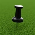 A black pushpin is embedded in a vibrant green, grass-like surface. The pushpin has a Royalty Free Stock Photo