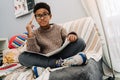 Black puzzled boy doing homework while sitting on sofa Royalty Free Stock Photo